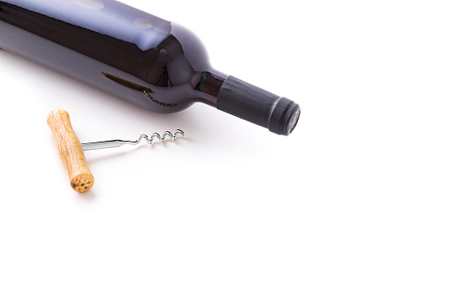 Glass wine bottle and corkscrew on a white background top view. Copyspace, vintage.