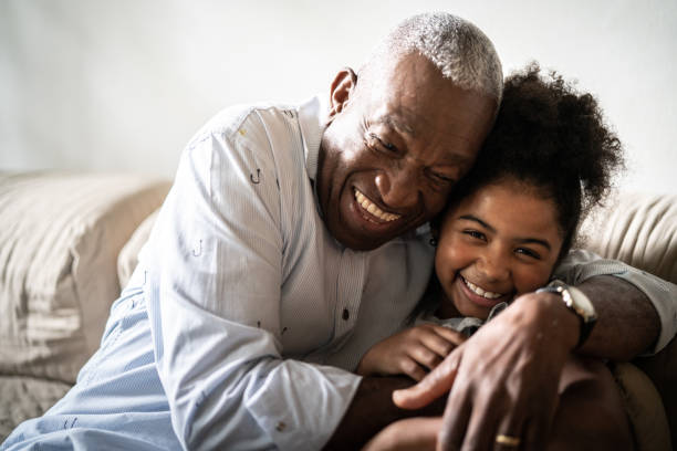 retrato de abuelo abrazando a nieta en casa - grandparent adult smiling looking at camera fotografías e imágenes de stock