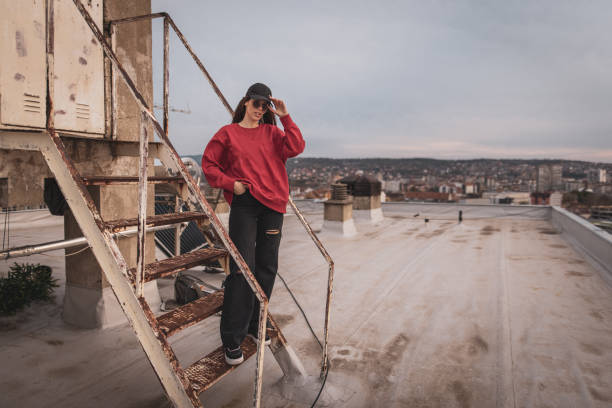 istock Young hipster woman with cap sitting on staircase on rooftop 1313094812