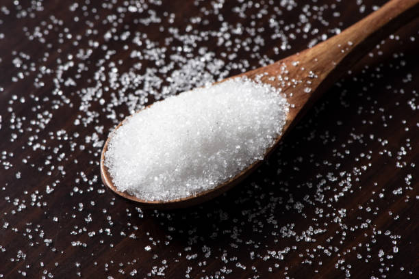 istock Spoon with white sugar on wood background 1313103561