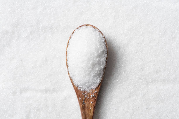 istock Spoon with white sugar on sugar background 1313104673