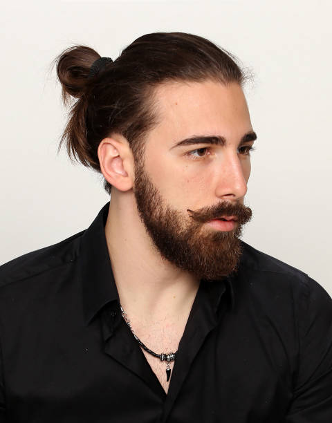 istock Attractive young male model with long hair and beard is posing in studio. 1313105466