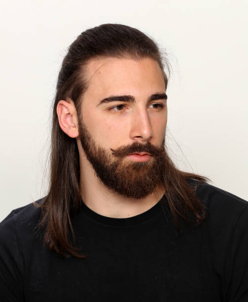 istock Attractive young male model with long hair and beard is posing in studio. 1313105598
