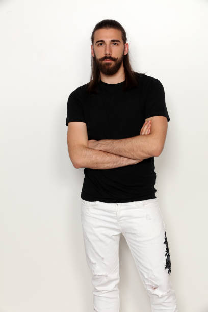 istock Attractive young male model with long hair and beard is posing in studio. 1313105789