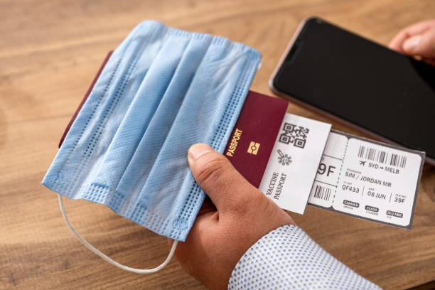 The businessman is holding a vaccination passport to travel abroad. The businessman is holding a vaccination passport to travel abroad. vaccine passport photos stock pictures, royalty-free photos & images