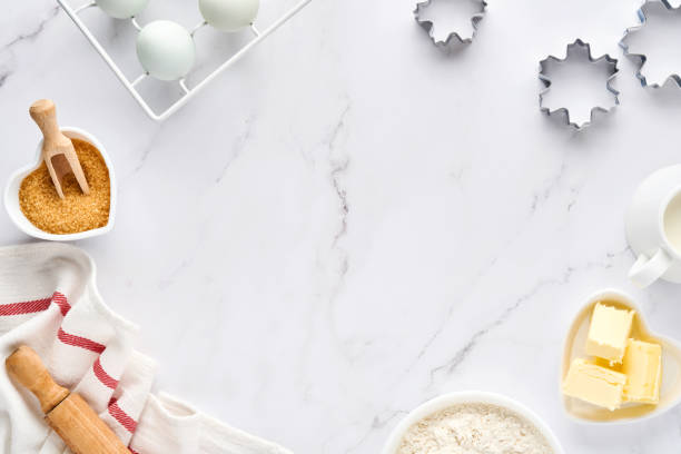istock Baking background with flour, eggs, kitchen tools, utensils and cookie molds on white marble table. Top view. Flat lay style. Mock up. 1313109811