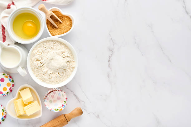 istock Baking background with flour, eggs, kitchen tools, utensils and cookie molds on white marble table. Top view. Flat lay style. Mock up. 1313110207