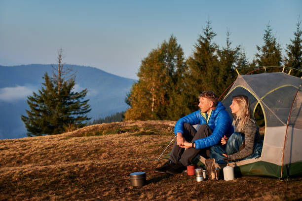 istock Pair having rest in campsite in mountains at sunny autumn. 1313110254