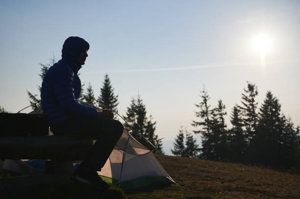 istock One man having rest in campsite in fresh air. 1313110279