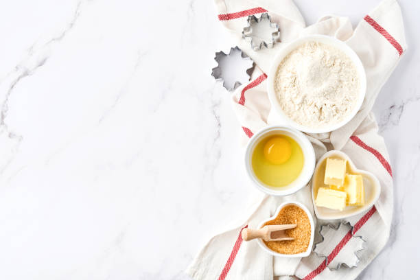 istock Baking background with flour, eggs, kitchen tools, utensils and cookie molds on white marble table. Top view. Flat lay style. Mock up. 1313110364