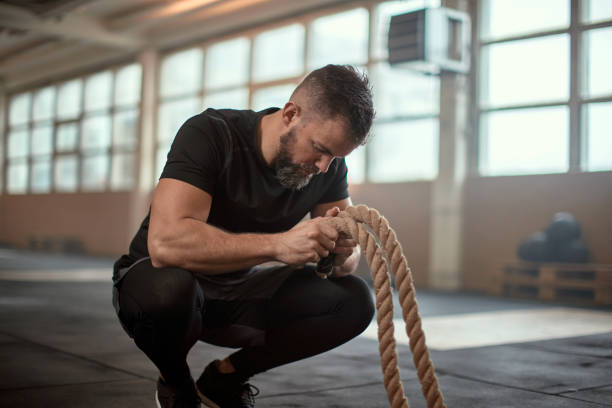 istock Fit man holding battle ropes in a gym 1313111800