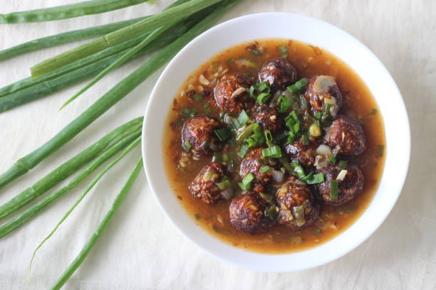 Veg Manchurian. A tasty Indo Chinese dish with air fried vegetable balls in a spicy, sweet and tangy sauce. The vegetable ball is made of cabbage, carrot and capsicum. Shot on white background Veg Manchurian. A tasty Indo Chinese dish with air fried vegetable balls in a spicy, sweet and tangy sauce. The vegetable ball is made of cabbage, carrot and capsicum. Shot on white background tangy stock pictures, royalty-free photos & images