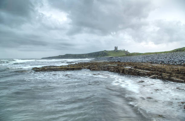 istock Dunstanburgh castle with rocky beach and sea. 1313115155