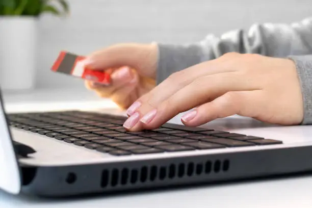 Photo of Hands on keyboard, woman enters data using a laptop. Online shopping or problems with a blocked credit card and account, rejected and invalid payment for purchases, financial fraud, theft or debt