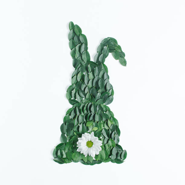 istock Creative Easter composition with bunny shape made of green natural leaves and flower. Minimal spring holiday background. Flat lay. Top view. 1313116535