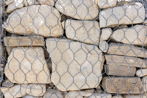 Stones and pebbles wall in wire mesh