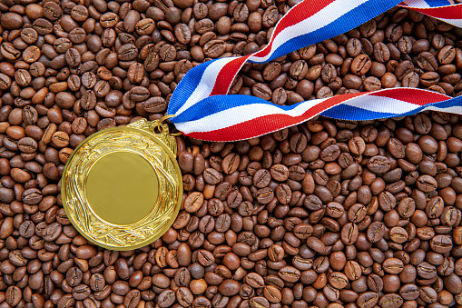 Gold medal with ribbon on coffee beans