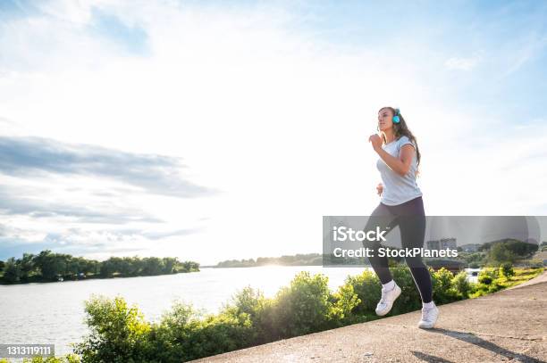 Teenager Girl Exercise At The Riverbank Stock Photo - Download Image Now - Jogging, Riverbank, Running