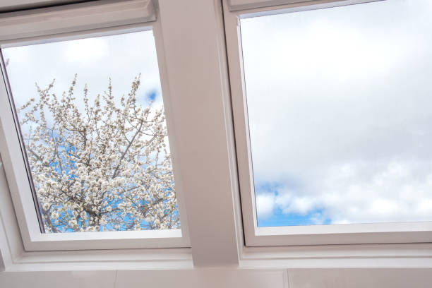 A modern open skylight,mansard window against blue sky with beautiful tree with white flowers, modern new house design, architectural detail A modern open skylight,mansard window against blue sky with beautiful tree with white flowers, modern new house design, architectural detail closeup skylight stock pictures, royalty-free photos & images