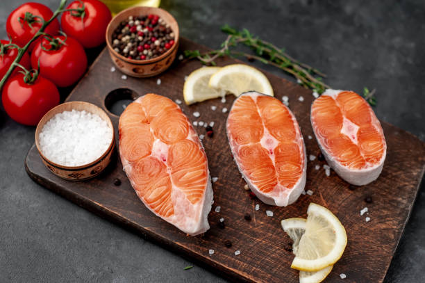 istock fresh raw salmon steaks on a stone background with salt, pepper, tomatoes, lemon 1313125428
