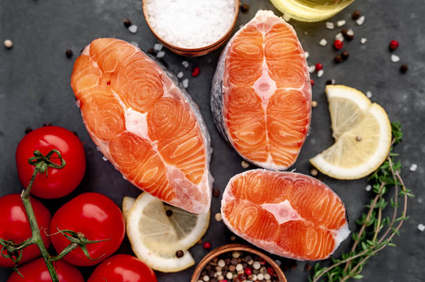 istock fresh raw salmon steaks on a stone background with salt, pepper, tomatoes, lemon 1313126076