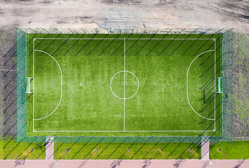 Aerial view of football field with green grass in the park.