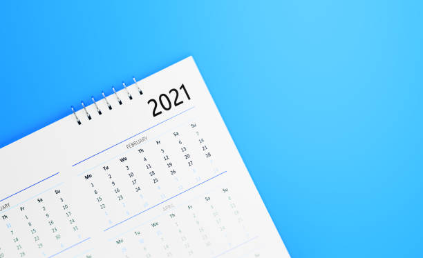 istock Calendar Concept - White 2021 Calendar Sitting On Blue Background 1313126402