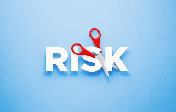 istock Cutting Risk Concept - Scissors Cutting The Word Risk Over Blue Background 1313127401
