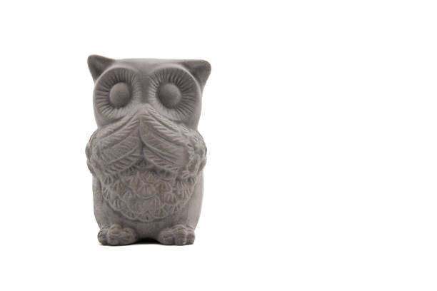 Praying owl (Strigiformes) carved out of stone. Isolated on white. Front view. Copy Space.