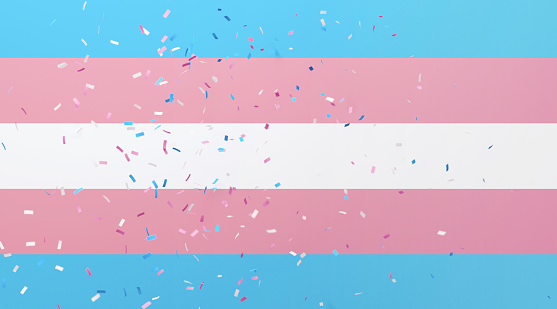 Confetti falling on transgender pride flag background. Horizontal composition with copy space. Front view. Transgender pride flag concept.