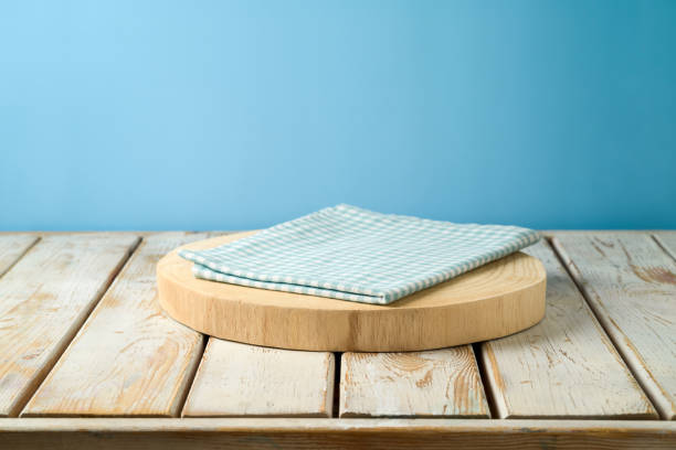 istock Empty wooden log with tablecloth on rustic table over blue wall  background.  Kitchen mock up for design and product display. 1313132791