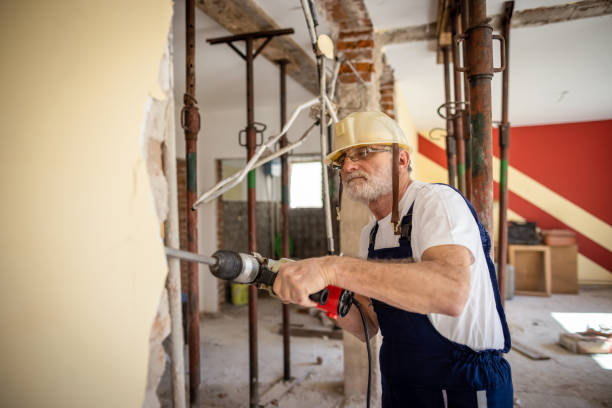 istock Senir bricklayer using drilling machine on a reconstruction of house 1313135158