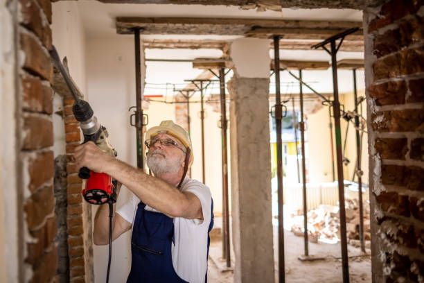istock Senir bricklayer using drilling machine on a reconstruction of house 1313135176