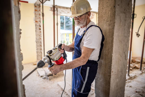istock Senir bricklayer using drilling machine on a reconstruction of house 1313135219