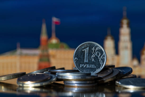 Coin in denomination of 1 Russian ruble on a pile of other coins Coin in denomination of 1 Russian ruble on a pile of other coins in front of symbolic out-of-focus fragments of the Moscow Kremlin russian culture stock pictures, royalty-free photos & images