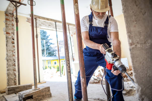 istock Senir bricklayer using drilling machine on a reconstruction of house 1313135405