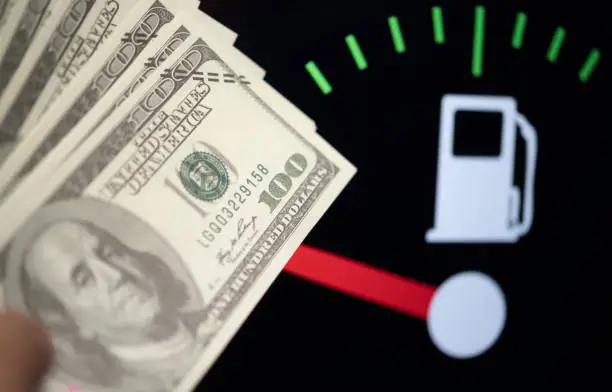 Dollar bank money coming from car fuel mileage dashboard concept closed on financial background