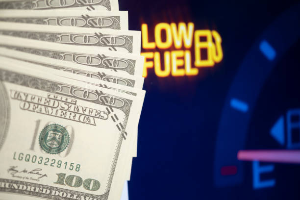 istock Dollar bills against oil mileage dashboard background 1313135504