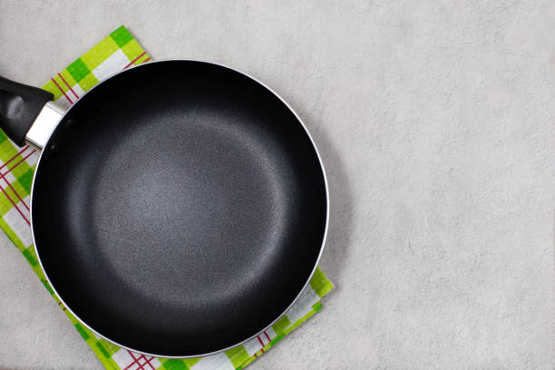 istock Empty black frying pan or skillet with green kitchen towel 1313135524