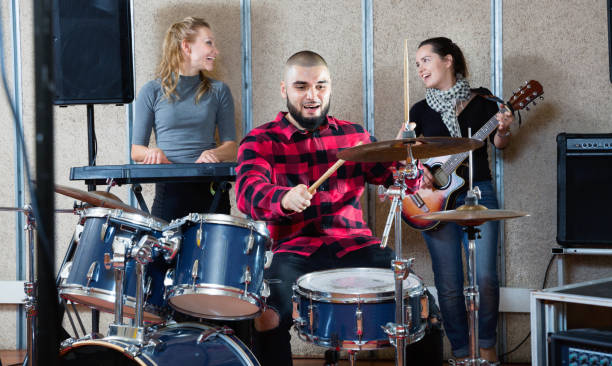 istock Expressive drummer with his bandmates practicing in rehearsal room 1313136914