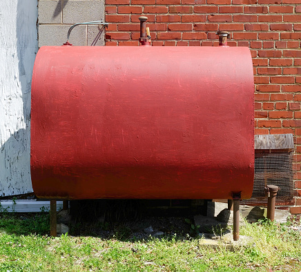 Freshly red painted home heating oil tank.