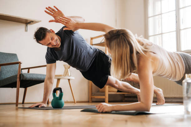 istock Happy fit couple having a great time while working out at home 1313146761
