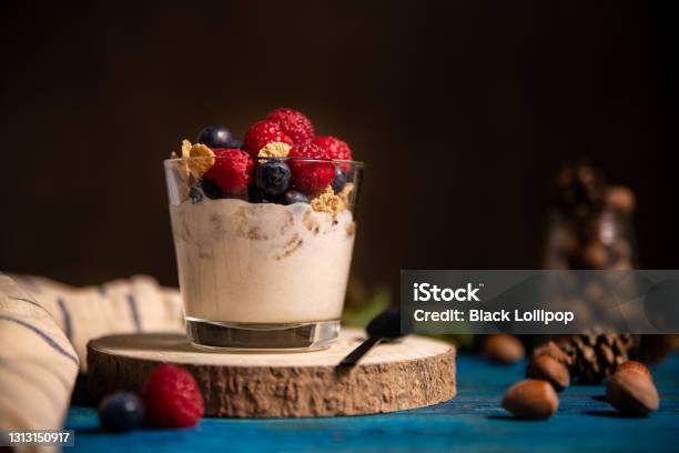 Granola With Yogurt And Berries For Healthy Breakfast On A Wooden Table Dark Style Photography Stock Photo - Download Image Now