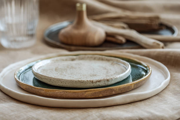 istock Table setting with Handmade craft plates on linen tablecloth and wood accessories in earth tones 1313151061