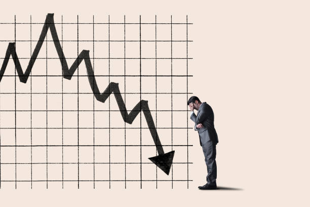 istock Man Leaning Head Against Declining Stock Chart 1313153508