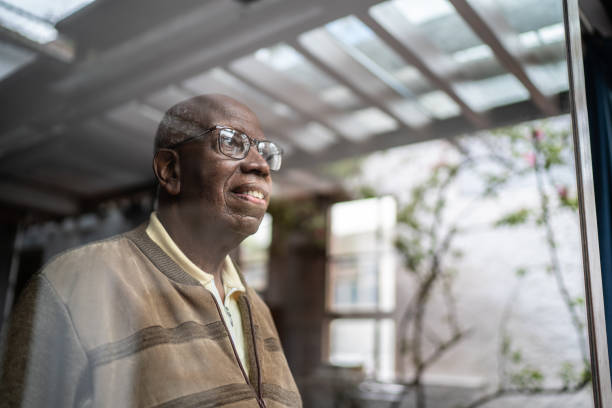 istock Senior man looking through the window contemplating at home 1313154450