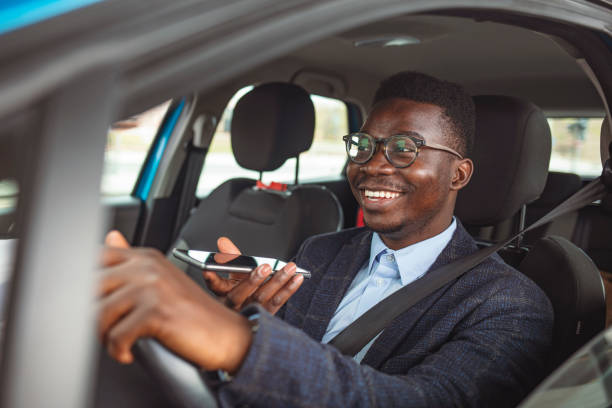 istock Young Man With Smartphone Driving Car. 1313154712