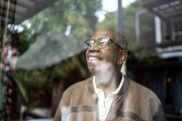 istock Senior man looking through the window contemplating at home 1313155503