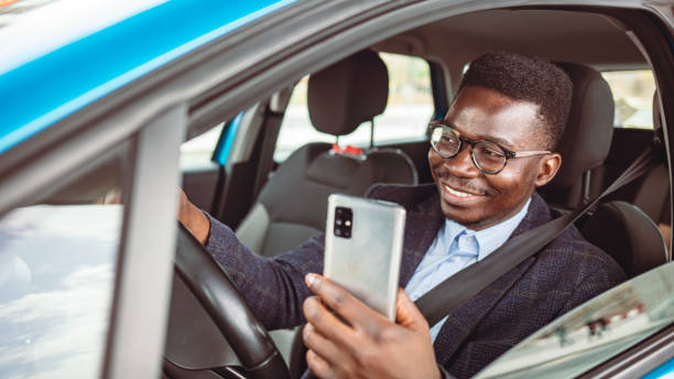 istock Businessman Dials a Message on the Smartphone in the Car. 1313155661