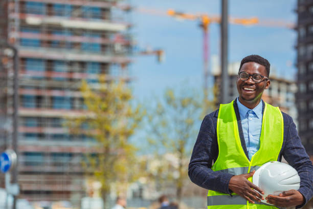 istock Architect worker holding white helmet a for workers security control at city site. 1313155782